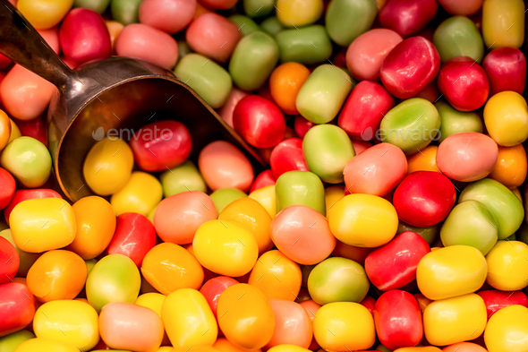 Fruit colorful gumballs candies background with the scoop. Pick and mix candy shop.
