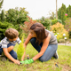 Mom and son planting plant together in garden - PhotoDune Item for Sale