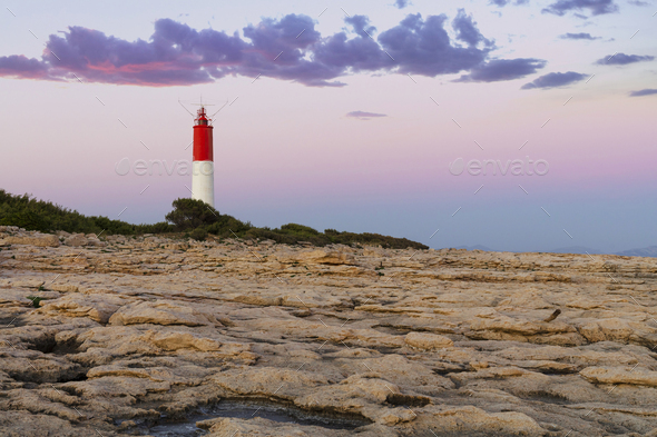 Rocky landscape with lighthouse over clear sky