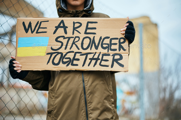 Close up of woman supports people of Ukraine with \'we are stronger together\' message on placard.
