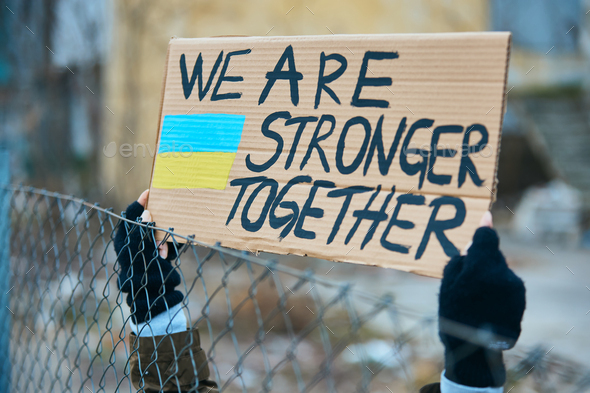 Close-up of Ukrainian protester holding placard with \'we are stronger together\' message.