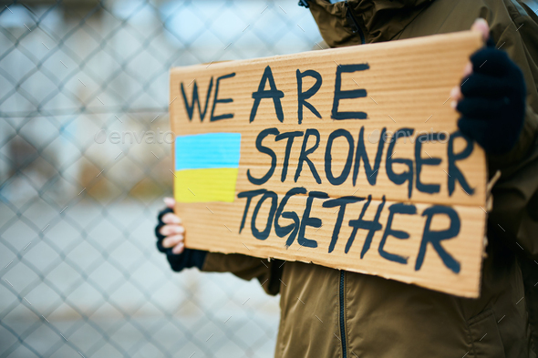 Close-up of anti-war activist with 'we are stronger together' message during war in Ukraine.