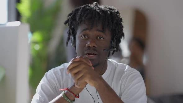 Web Camera POV of Serious Man in Earphones Talking with Blurred Woman Looking in Mirror at alt