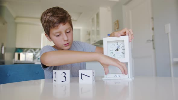 Boy Changing the Date on the Wooden Calendar on July 4 USA Independence Day alt