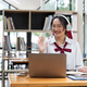Smiling asian woman in headset waving hand, using laptop, looking at screen, call center operator - PhotoDune Item for Sale