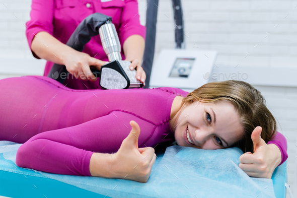 cosmetologist doing anticellulite LPG massage for woman in pink lpg suit. Beauty woman smiling and