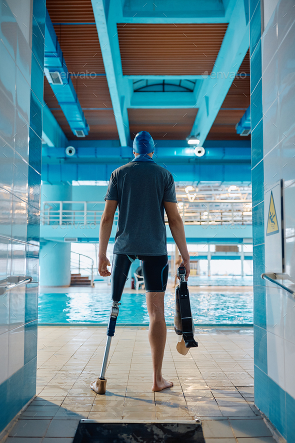 Back view of adaptive swimmer in front of indoor swimming pool. - Stock Photo - Images
