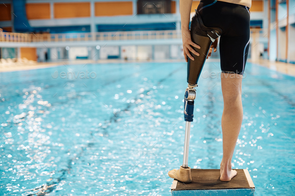 Rear view of swimmer with a prosthetic leg at starting block. Stock ...