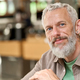 Happy smiling middle aged gray-haired man close up headshot. Older