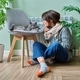 Cold winter season, woman with cat on chair near heating radiator - PhotoDune Item for Sale