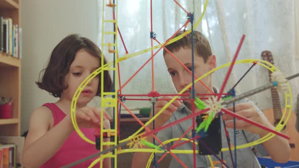 Boy and girl building a tower from toys at home alt