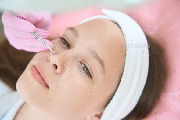 Portrait of teenage girl while cleaning face with uno spoon - Stock Photo - Images