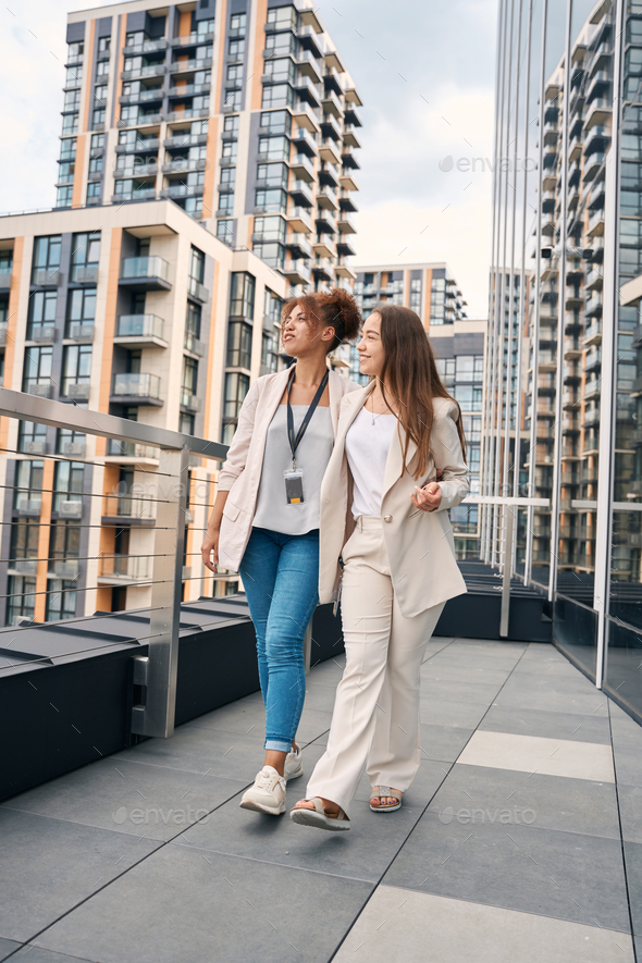 Elegant business ladies looking at cityscape during lunch walk - Stock Photo - Images