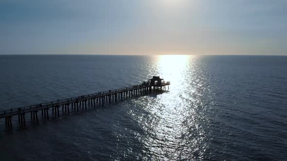 Flying Along a Wooden Long Pier at Sunset Time.