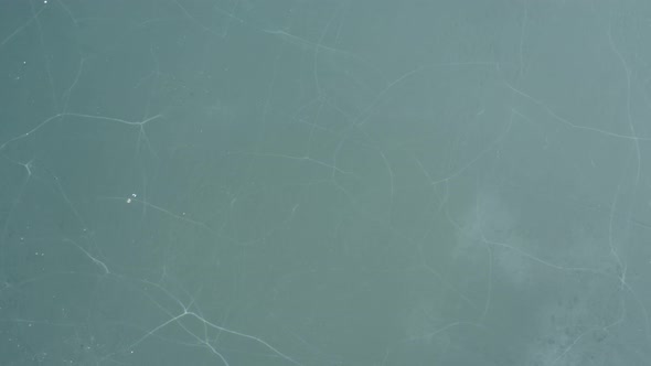 AERIAL: Rotating Shot of Fractured Ice on Lake  alt