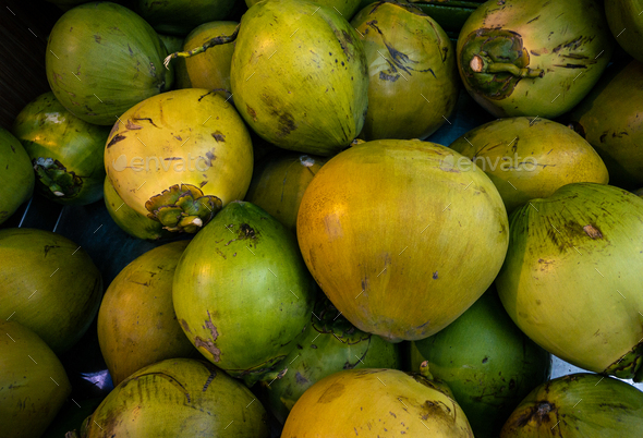 Green coconut heap on market. Cocos asian traditional farmers food marketplace