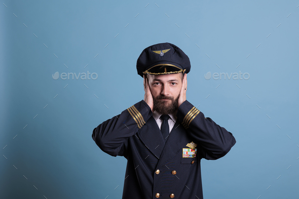 Airliner pilot covering ears with hands
