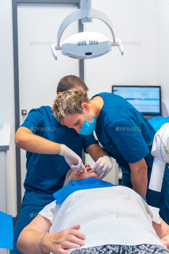 Dental clinic, dentist doctor and assistant examining the teeth of an elderly woman