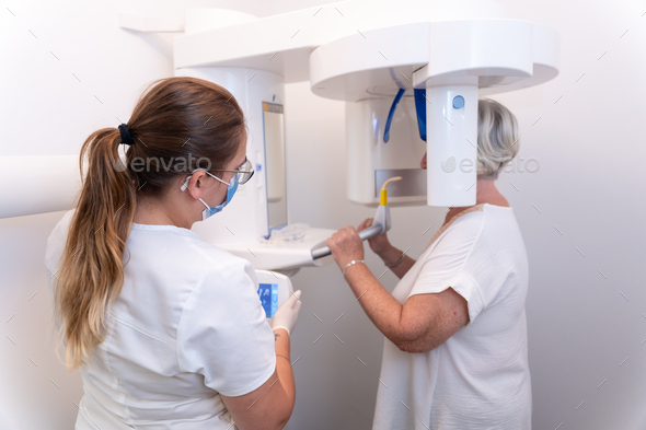 Dental clinic, dental assistant with an elderly woman in the x-ray room
