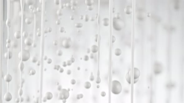 Super Slow Motion Shot of Dripping Milk on White Background at 1000 Fps. alt