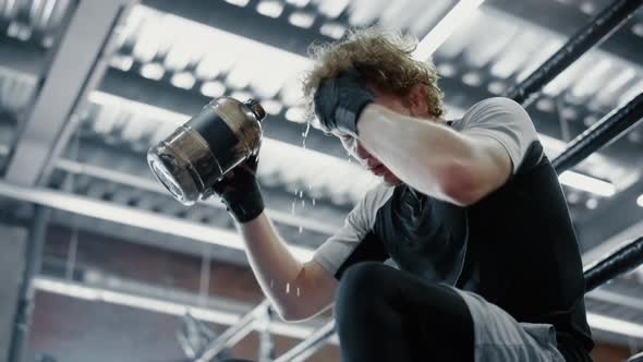 Hot Fighter Quenching Thirst in Fitness Center. Kickboxer Refreshing at Gym alt