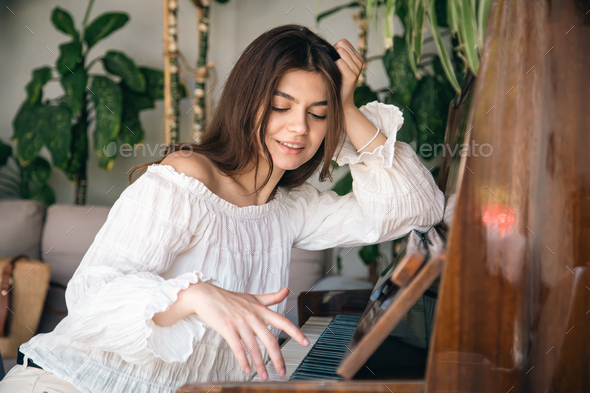 ung kvinna spelar det gamla träpianotung kvinna spelar det gamla träpianot  