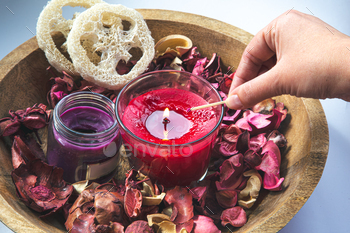 Composition with burning aroma candles among rose petals.