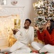 Portrait of happy black couple throwing gifts in the air while sitting near Christmas tree - PhotoDune Item for Sale