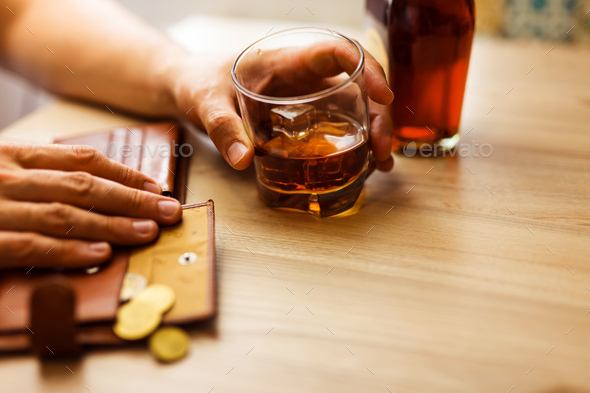 Fired man countsing his last money to drink expensive alcohol.