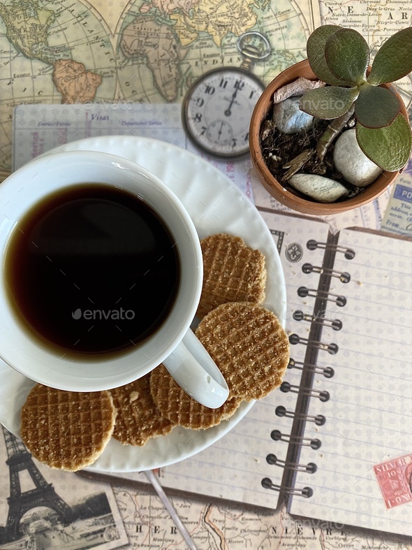 Coffee cup with biscuits on travel planner