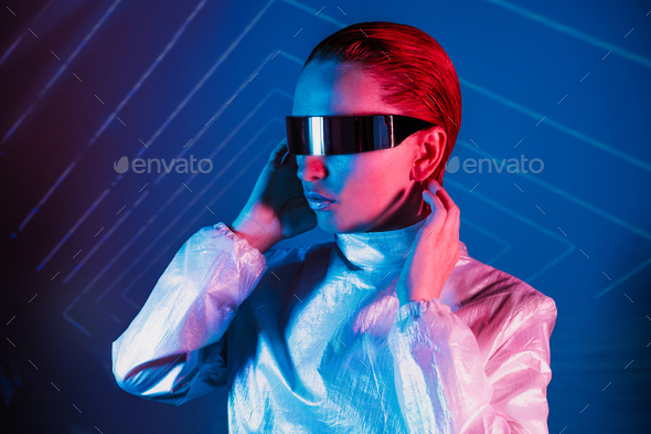 Neon portrait of woman, dressed in futuristic holographic clothes and glasses. Portrait of cyberpunk