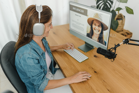 Radio host recording podcast and using computer Stock Photo by GabiStock