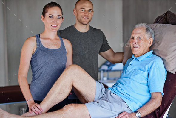 Our patients recovery is the only goal. Portrait of an elderly man and two physiotherapists.