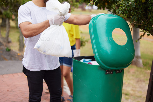 A new path leaves no clean hands. Shot of a man throwing trash in a bin ...