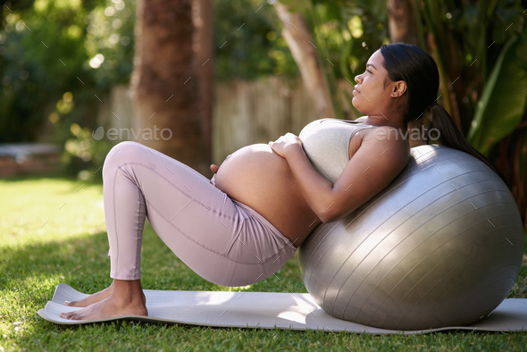 Fit mom, healthy baby. Shot of a pregnant woman working out with a stability ball outside.