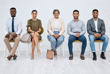 Studio portrait of a group of businesspeople sitting in line against a white background