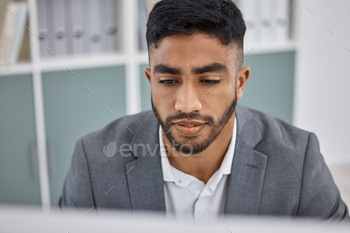 Shot of a young businessman working on a computer in an office