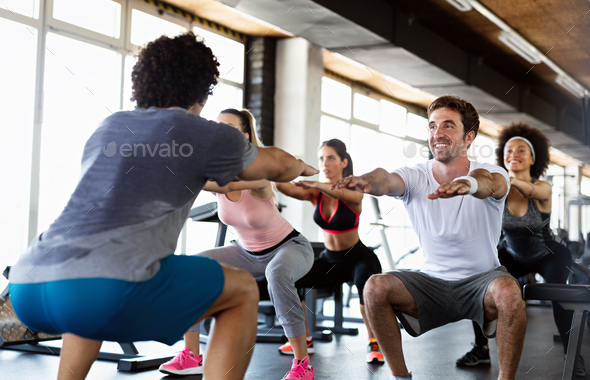 Group of young people, friends smiling and enjoy sport in gym. People  exercise, work out concept. Stock Photo by nd3000