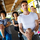 Multiethnic group of people training in a gym. Trainer and sportive fit persons exercising - PhotoDune Item for Sale