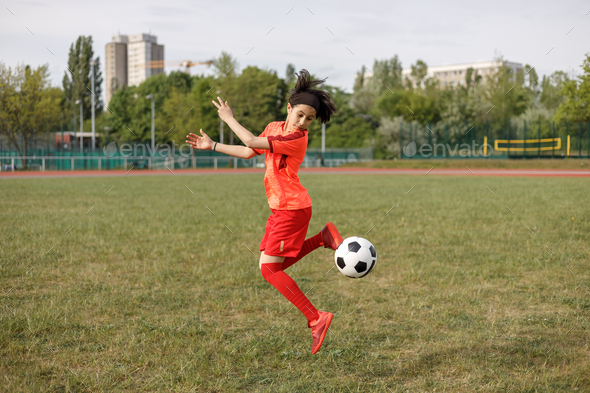 Girl kicking a soccer ball with her heel