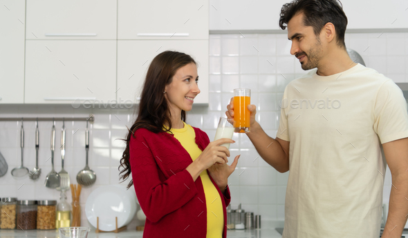 Pregnant woman in kitchen with the atmosphere of cooking with the husband to eat together