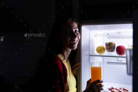A pregnant woman who wakes up late at night looking for food in the refrigerator