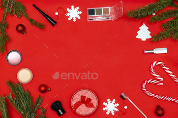 New year beauty cosmetics composition on red christmas background.