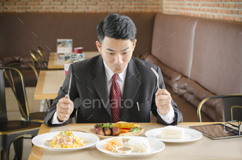 business man happy eating foods in  restaurant
