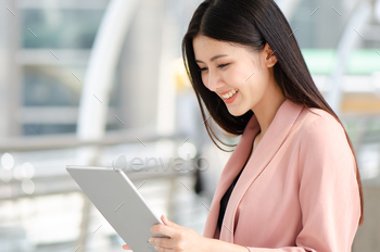 young asian woman smile watching her tablet doing purchase or buy shopping online