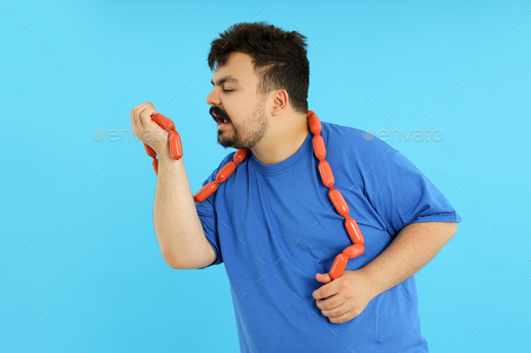 Concept of weight problems, young fat man on blue background