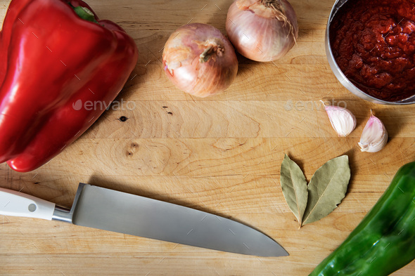 wooden cutting board with vegetables and a knife