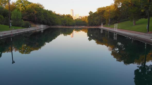 Flying straight down barton springs pool on a perfectly calm day. Downtown Austin TX in the backgrou alt