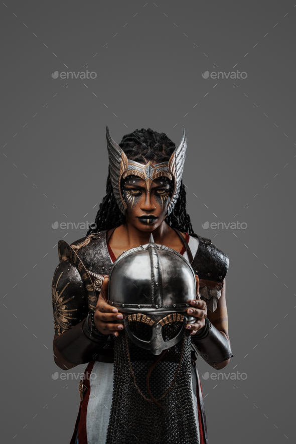 Attractive black woman warrior holding helmet staring at camera