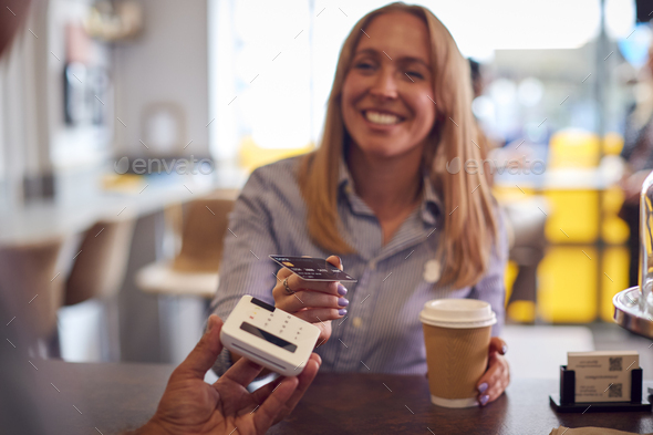 Female Customer Making Contactless Payment In Coffee Shop Using Debit Card - Stock Photo - Images